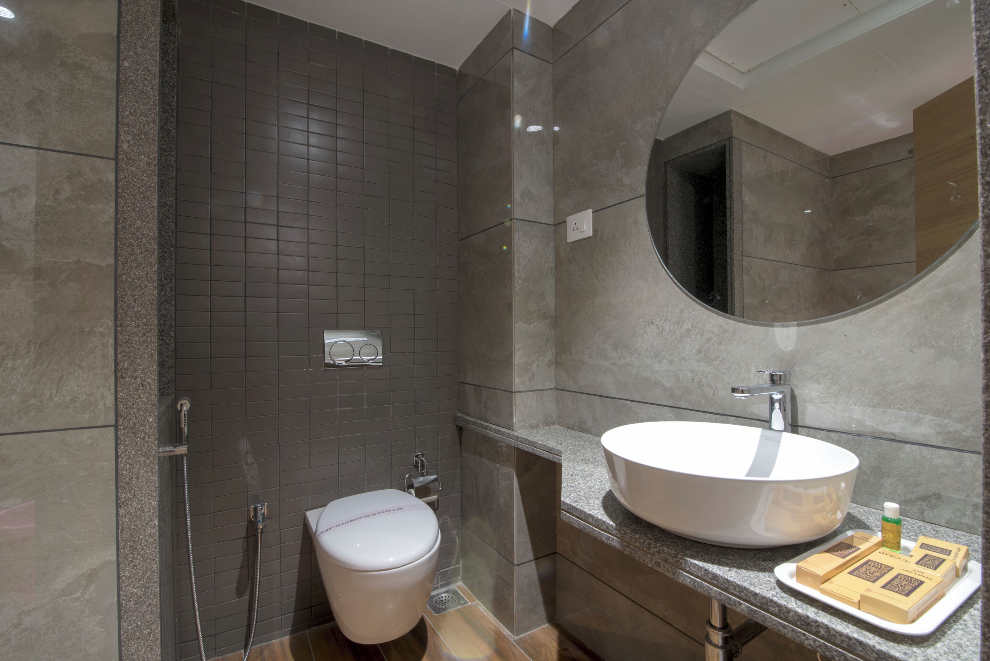 A modern bathroom with a large sink, toilet, and shower.