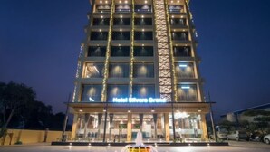 A hotel with a central fountain, a well-lit entrance, and a clear view of the building's facade. - Hotel Silvera Grand (Ahmedabad)