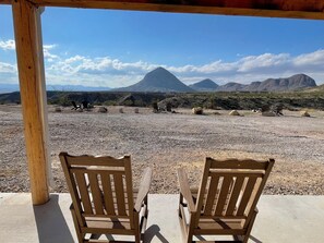 Two wooden chairs facing a rocky landscape with mountains in the background. - Ten Bits Ranch - Room #19 Lewis Land & Cattle Co. (Terlingua)