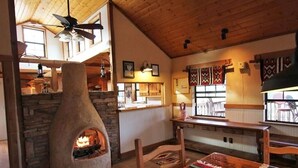 A rustic interior with a stone fireplace, wooden ceiling, and traditional decor. - Ten Bits Ranch - Room # 20 - Law Office (Terlingua)