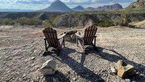 Two Adirondack chairs facing a rocky landscape with distant mountains under a clear sky. - Ten Bits Ranch - Room # 20 - Law Office (Terlingua)