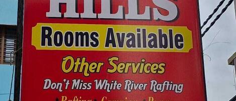 A hotel sign with the name 'HOTEL STAR HILLS' and a list of services including rafting, camping, and bike rental.