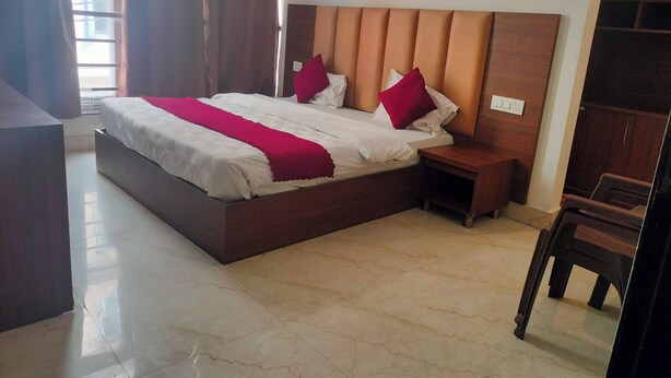 Ein Hotelzimmer mit einem großen Bett, einem Holzkopfende, Nachttischen und Blick ins Freie.