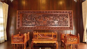 Ett traditionellt rum med träpanel, en stor, utsmyckad träpanel, två träbänkar och ett trägolv.