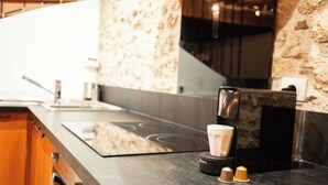 A modern kitchen with a black countertop, a coffee maker, and a cup of coffee. - Duplex "Le Bourgogne" historic center of Orléans (Orléans)