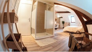 A bedroom with a large bed, a wooden chair, a glass shower enclosure, and a staircase. - Duplex "Le Bourgogne" historic center of Orléans (Orléans)