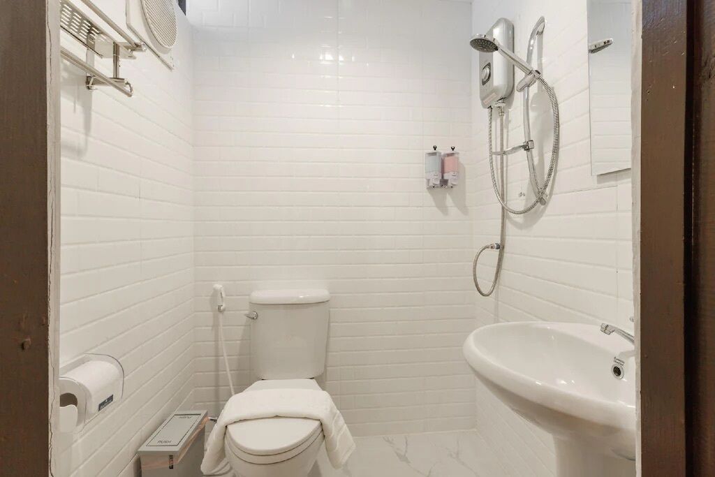 A small, white-walled bathroom with a toilet, bidet, and sink.