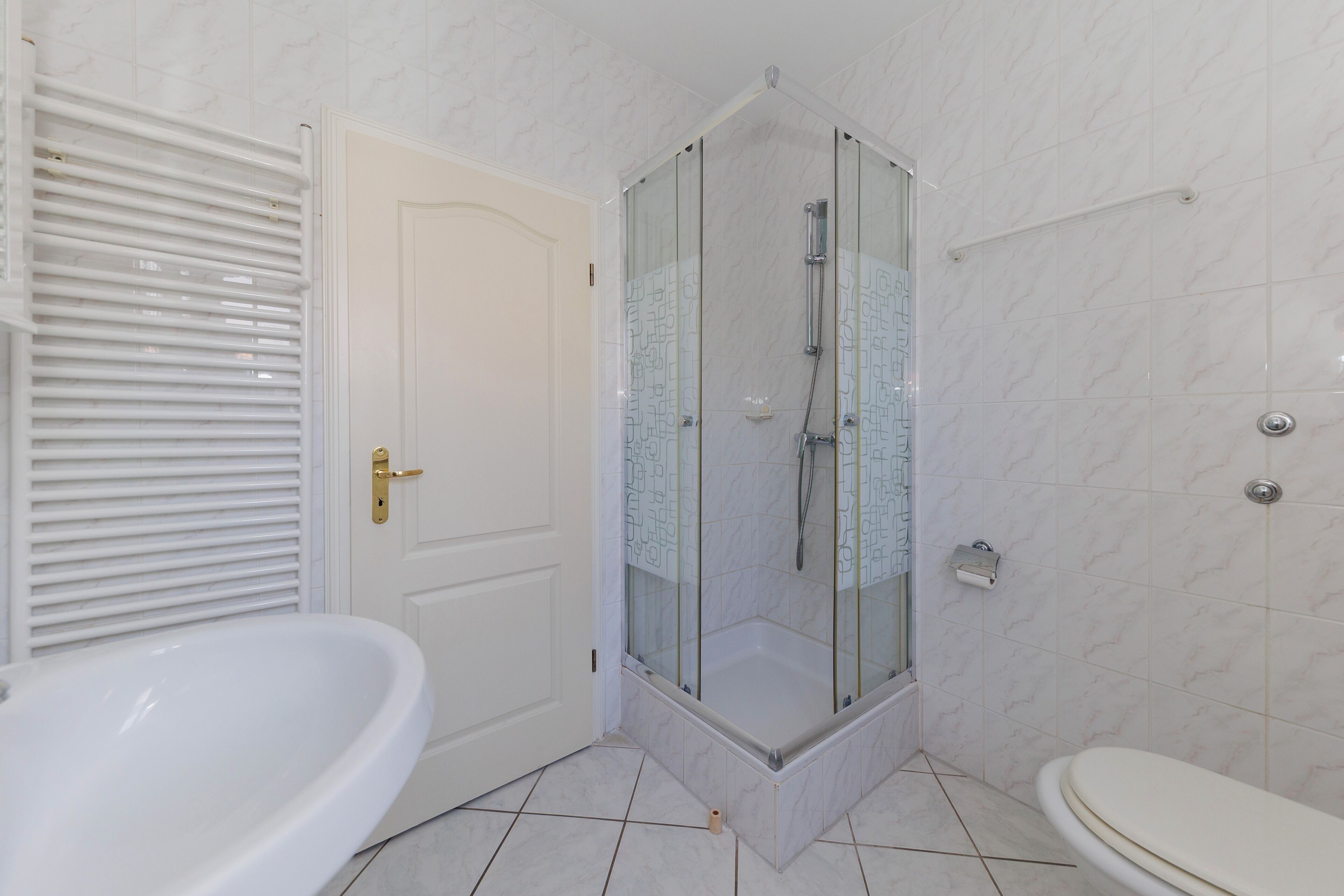 Un baño con ducha de vidrio, bañera independiente y retrete.