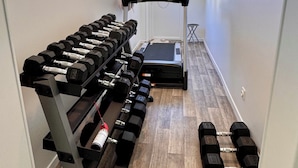 A home gym with a treadmill, dumbbells, and a weight bench. - Lovely self-contained studio in Roissy-en-France / Aeroport CDG with airport terrace (Roissy-en-France)
