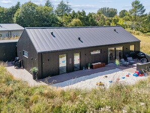 A modern house with a large deck, a covered outdoor area, and a view of surrounding greenery. - "Artur" - 800m from the sea by Interhome (Glesborg)