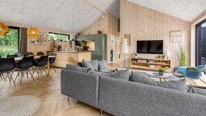 A modern living space with a dining area, kitchen, and a large TV. - "Artur" - 800m from the sea by Interhome (Glesborg)