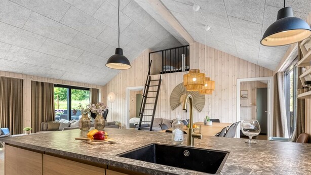 A kitchen with a marble countertop, black sink, and wooden cabinetry. - "Artur" - 800m from the sea by Interhome (Glesborg)