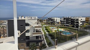 Un immeuble d’appartements moderne doté d’une piscine et offrant une vue sur la mer.