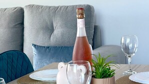 Une table à manger dressée avec des assiettes, des couverts et une bouteille de champagne.