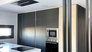Une cuisine moderne dotée d’un îlot central, d’un four encastré et d’un four à micro-ondes.