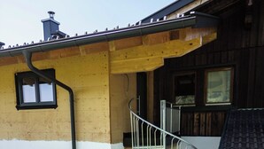 A two-story house with a spiral staircase, a small porch with steps, and a bicycle. - Studio Terra Salzburg Ecosuite (Altenmarkt im Pongau)