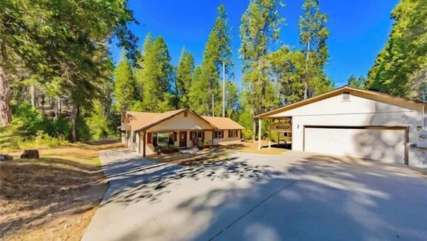 A two-story house with a garage, surrounded by trees. - The Lady Bug Family Retreat (Mariposa)