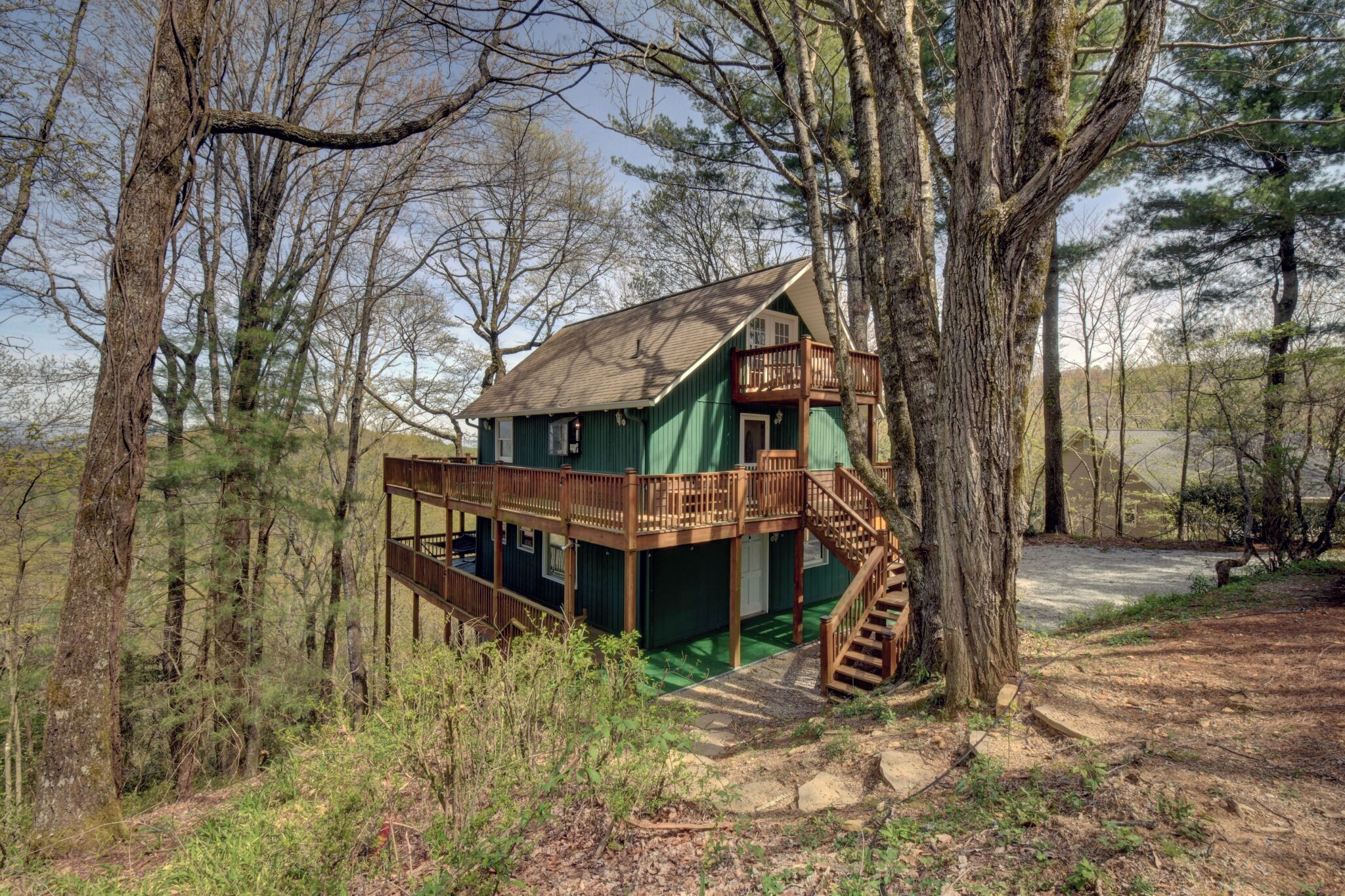 Een chalet met een houten terras en een spiltrap.