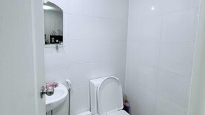 A small, white bathroom with a toilet, sink, and shower. - Fabulous building with AC in vibrant Cebu City (Cebu City)