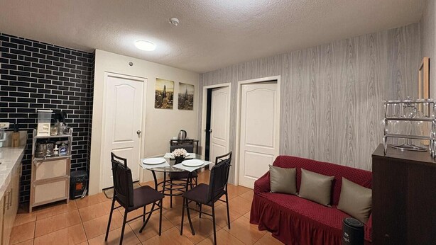 A compact living space with a kitchen, dining area, and a red sofa. - Fabulous building with AC in vibrant Cebu City (Cebu City)