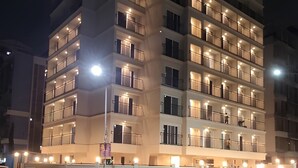 A multi-story hotel with illuminated balconies and a prominent sign on the top.