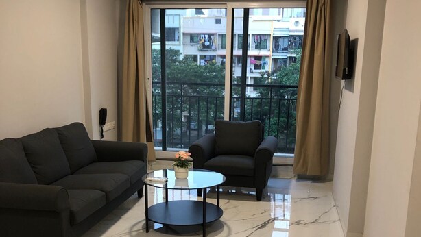 A modern living room with a sofa, armchair, and a coffee table.