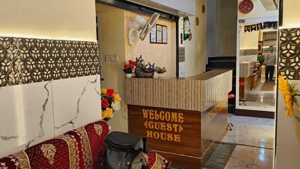 Un área de recepción con una pared de mármol, un mostrador de madera y un sofá.