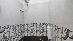 Un baño pequeño con inodoro, lavabo y ducha. Las paredes tienen un diseño con remolinos.