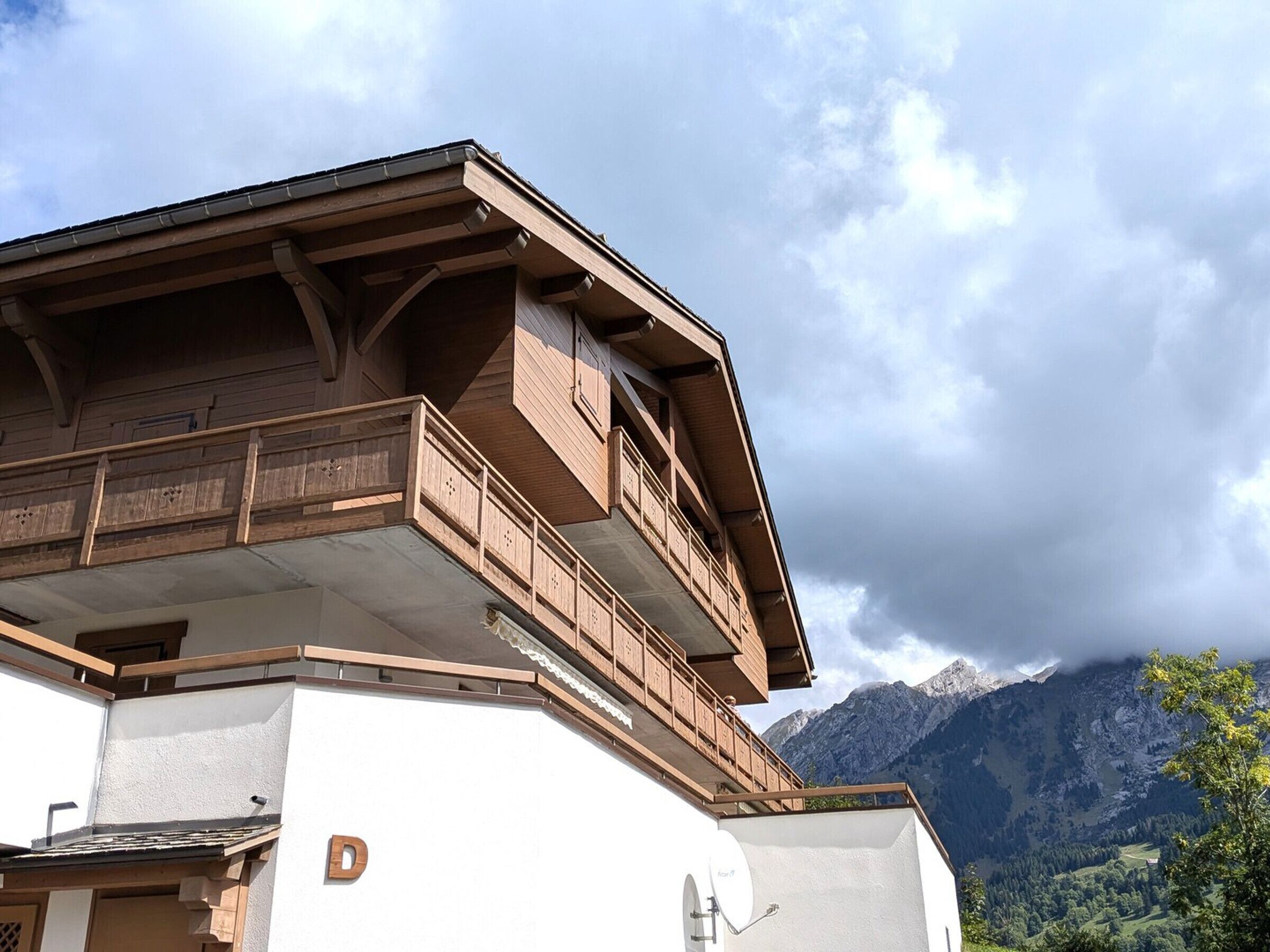 A building with a wooden balcony and a satellite dish.
