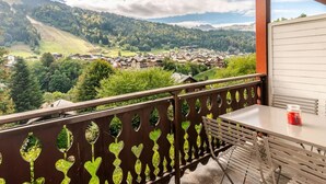 A balcony with a view of a village and mountains.