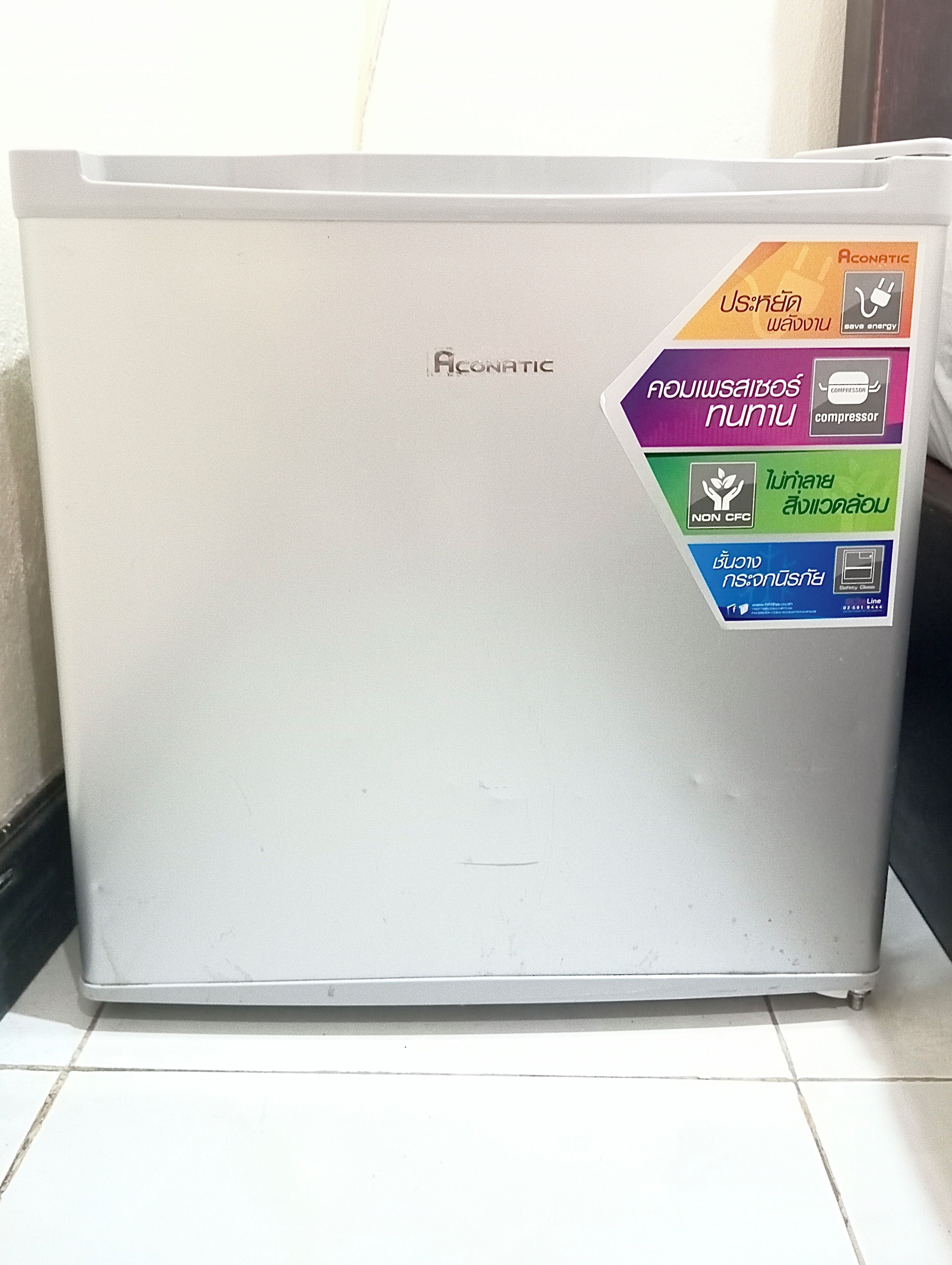 A white Aconatic refrigerator with a sticker highlighting its energy-saving features.