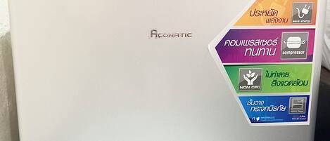 A white Aconatic refrigerator with a sticker highlighting its energy-saving features.