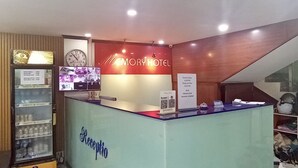 A reception desk with a clock, a refrigerator, and a sign for Memory Hotel. - Memory Hotel Vientiane  (Vientiane)