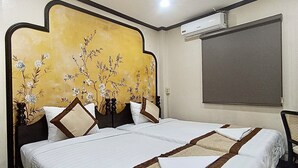 A hotel room with two beds, a large decorative headboard, and an air conditioning unit on the wall. - Memory Hotel Vientiane  (Vientiane)