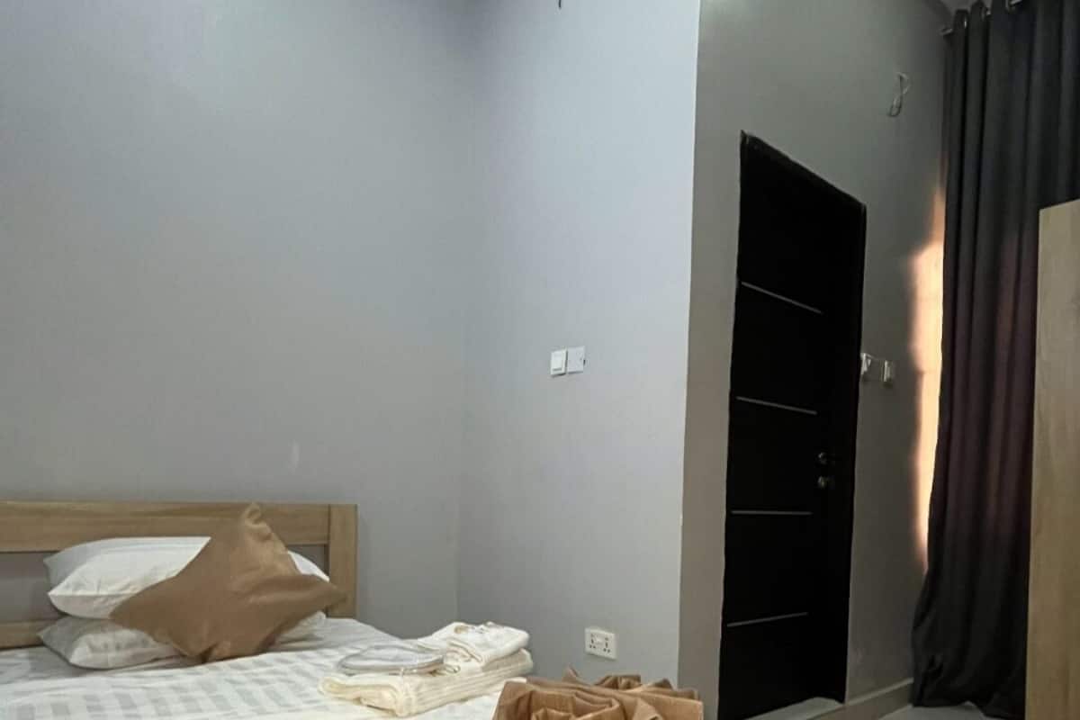 A bedroom with a bed, a wardrobe, and a door.