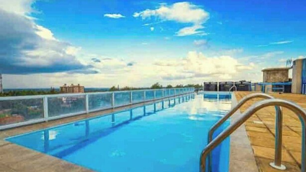 A rooftop swimming pool with a clear view of the city skyline. - Classy One bed airbnb by Miss Omuts,pool (Nairobi)