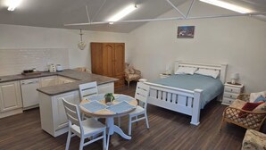 A compact room with a kitchenette, a bed, and a dining area. - Tipsy Hill Cottage, River Views at Walker Flat SA. Perfect for a weekend getaway (Forster)