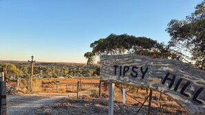 A rustic wooden sign with 'TIPSY HILL' written on it, surrounded by dry grass and a fence. - Tipsy Hill Cottage, River Views at Walker Flat SA. Perfect for a weekend getaway (Forster)