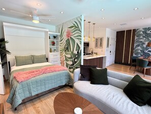 Une chambre moderne comprenant un lit, un canapé, un petit coin cuisine et un espace repas.