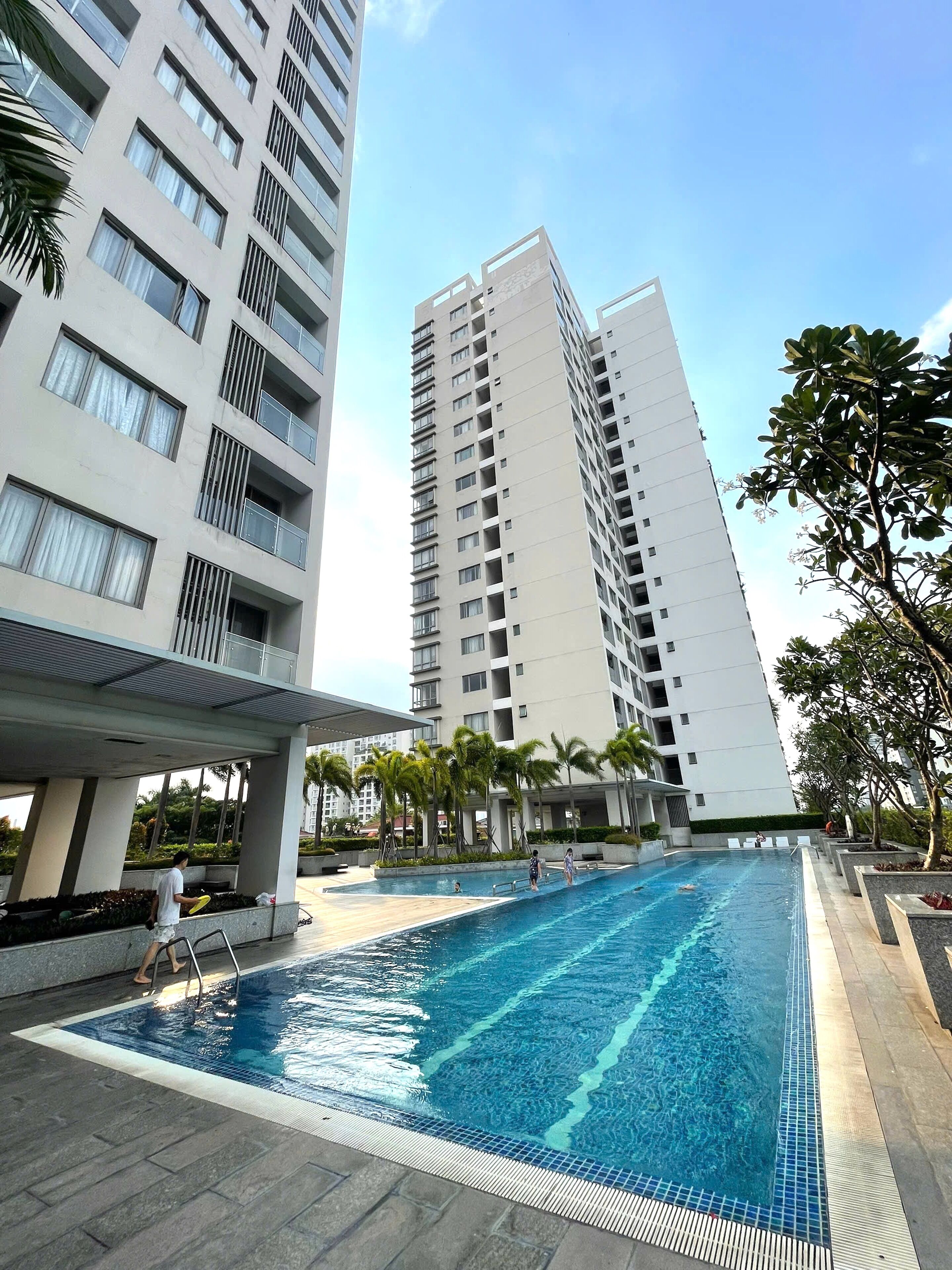 A swimming pool area with a modern building in the background.