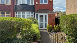 A two-story house with a bay window, a front door, and a number 273 sign. - Manchester Home Away From Home (Manchester)