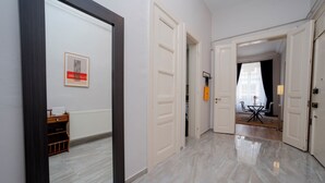 A hallway with white doors, a mirror, and a framed picture on the wall. - 3-Bedroom, 2-Bathroom with High Ceilings, Spacious Layout and No Stairs (İstanbul)