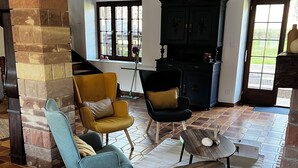 A spacious living room with a fireplace, a yellow armchair, a blue armchair, and a wooden coffee table. - New home! La Buissonnière, 12 to 14 pers with Spa, 45min from Strasbourg. (Erckartswiller)