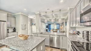 A modern kitchen with granite countertops, stainless steel appliances, and pendant lighting. - 42 Sandcastle | Free Heated Pool | 3 Blocks to the Beach | Elevator (Hilton Head Island)