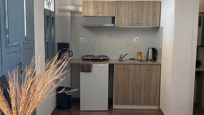 Una cocina compacta con armarios de madera, una encimera blanca y un lavamanos pequeño.