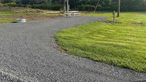 A gravel path leading to a picnic table surrounded by grass and trees. - Private campsite in Pulaski for a peaceful get away. (Pulaski)