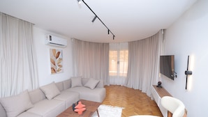 Un salon moderne avec un canapé, une table basse et un téléviseur fixé au mur.