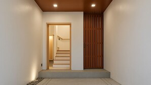 Un pasillo con una puerta de madera, una escalera y un escalón que lleva a una puerta.