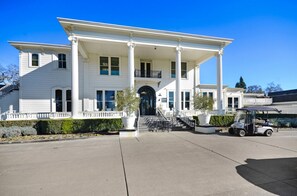 Un grand bâtiment blanc, doté d’une entrée imposante, de colonnes et d’un porche abrité.