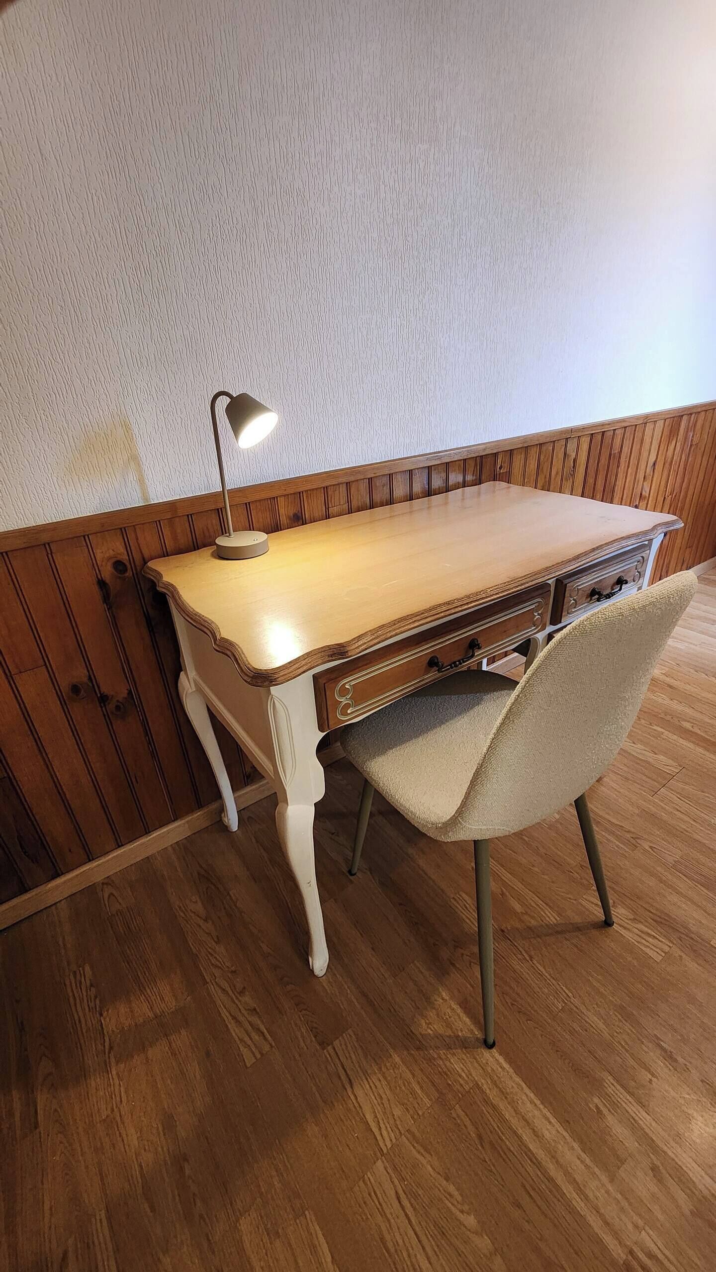 Ein Holztisch mit einer Lampe, einem Stuhl und Holzboden.